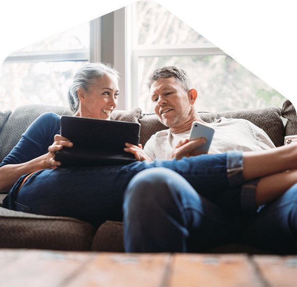 two-homeowners-using-gadgets-in-couch